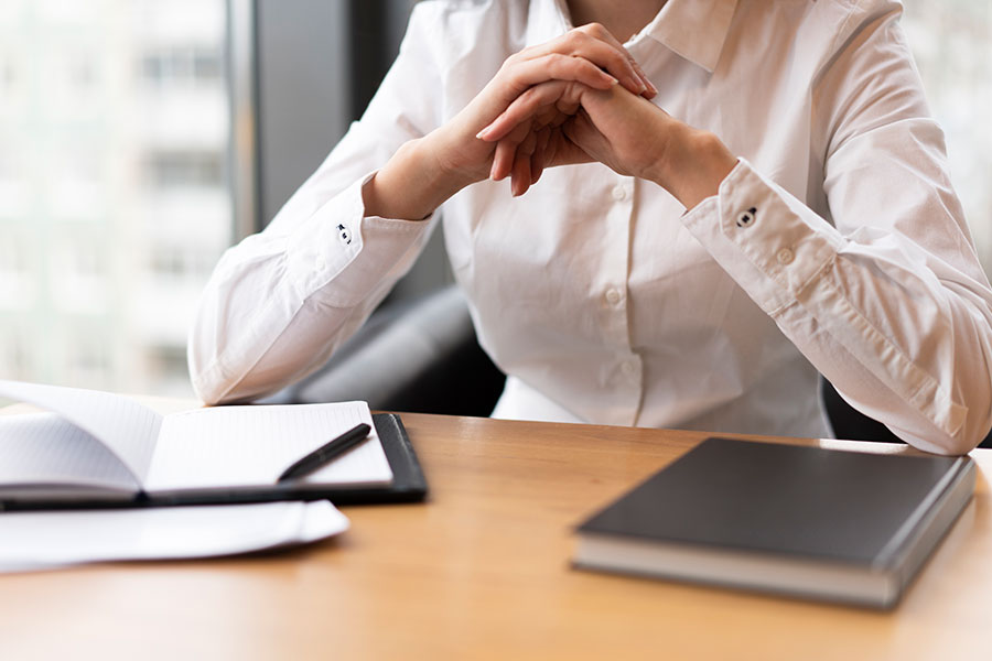 Professionista alla scrivania con agenda e documenti durante una consulenza